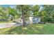 Exterior view of home with garage and driveway, surrounded by mature landscaping at 4818 Huron St, Zephyrhills, FL 33541