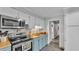 Well-lit kitchen with stainless steel appliances, blue cabinets, and wood countertop at 4818 Huron St, Zephyrhills, FL 33541