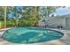In-ground pool with blue trim and built-in steps leads to an outdoor dining area in the backyard at 4818 Huron St, Zephyrhills, FL 33541