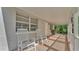 Covered porch with white rocking chairs offers a relaxing outdoor space to enjoy the view at 4818 Huron St, Zephyrhills, FL 33541