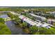 Aerial view of the condo community, showcasing building exteriors, lake, landscaping, and parking areas at 5980 80Th N St # 408, St Petersburg, FL 33709