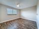 Simple bedroom with a large window, wood flooring, white trim and neutral colored walls at 5980 80Th N St # 408, St Petersburg, FL 33709