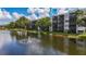 Exterior view of the condo buildings, showcasing the lake, fountain, balconies, and well-maintained landscaping at 5980 80Th N St # 408, St Petersburg, FL 33709