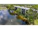 Exterior view of the condo buildings, showcasing the lake, fountain, balconies, and lush greenery at 5980 80Th N St # 408, St Petersburg, FL 33709