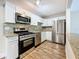 Updated kitchen with stainless steel appliances, granite counters, and modern white cabinets at 5980 80Th N St # 408, St Petersburg, FL 33709