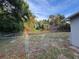 Large backyard featuring a chain-link fence, shrubs, and green trees at 14002 Morgan St, Dade City, FL 33525