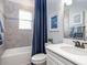 Bathroom with vanity, toilet, window and a shower-tub combo with a blue curtain at 2626 Scenic Park Loop, Wimauma, FL 33598