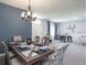 Elegant dining room with modern chandelier, seating for six, and decorative blue accent wall at 2626 Scenic Park Loop, Wimauma, FL 33598