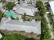 Aerial view of the community pool, parking, and building exteriors surrounded by tropical landscaping at 3608 54Th W Dr # 202, Bradenton, FL 34210