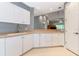 Well-lit kitchen with white cabinetry, tile flooring, and views to the living area at 3608 54Th W Dr # 202, Bradenton, FL 34210