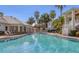 Large swimming pool featuring lounge chairs, tropical landscaping, and well-maintained condo buildings at 3608 54Th W Dr # 202, Bradenton, FL 34210