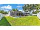 Aerial view of this beautiful backyard featuring a pool, covered patio, and green grass at 3911 Smoke Rise Ct, Valrico, FL 33594