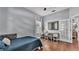 A light blue bedroom featuring hardwood floors, a comfortable bed, and a writing desk by the window at 3911 Smoke Rise Ct, Valrico, FL 33594