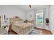 A bright bedroom with hardwood floors, a comfortable bed, and a writing desk with views to the backyard at 3911 Smoke Rise Ct, Valrico, FL 33594