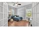 Bright bedroom with a comfortable bed, desk area, and natural light through the windows and french doors at 3911 Smoke Rise Ct, Valrico, FL 33594