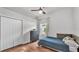 This bedroom features wood floors, ceiling fan, closet, and natural light from the window at 3911 Smoke Rise Ct, Valrico, FL 33594