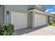 Three car garage showing white garage doors and green landscaping at 3911 Smoke Rise Ct, Valrico, FL 33594