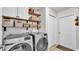Neat laundry room with a full-size washer and dryer and shelving at 3911 Smoke Rise Ct, Valrico, FL 33594