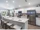 Modern kitchen featuring stainless steel appliances, a granite countertop island with seating, and stylish white cabinets at 6926 161St E Ter, Parrish, FL 34219