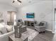 Living room with neutral decor, accent chairs, and a mounted flatscreen TV for comfortable relaxation at 6926 161St E Ter, Parrish, FL 34219