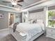 Spacious main bedroom featuring a tray ceiling, ceiling fan and an ensuite bath at 6926 161St E Ter, Parrish, FL 34219