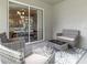 Covered patio with woven outdoor furniture and sliding door access to the interior at 6926 161St E Ter, Parrish, FL 34219