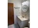 Bright bathroom featuring a vanity with white countertop, round mirror, and tiled walls, creating a clean and functional space at 704 Queens Ct, Seffner, FL 33584