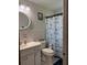 Bathroom with vanity, round mirror, nautical shower curtain, and neutral tile at 704 Queens Ct, Seffner, FL 33584