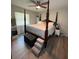 Spacious main bedroom with a four-poster bed, ceiling fan, and hardwood floors at 704 Queens Ct, Seffner, FL 33584