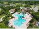 Stunning aerial view of a community pool area with ample seating, lush landscaping, and inviting amenities at 1044 Oliveto Verdi Ct, Brandon, FL 33511