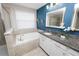 Serene bathroom with a soaking tub, granite countertop vanity, and modern fixtures at 1044 Oliveto Verdi Ct, Brandon, FL 33511