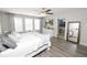 Bright primary bedroom with large windows, a full-length mirror, and en-suite bathroom access at 1044 Oliveto Verdi Ct, Brandon, FL 33511