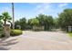 Elegant gated community entrance featuring lush landscaping, mature trees, and a secure entry system for residents' peace of mind at 1044 Oliveto Verdi Ct, Brandon, FL 33511