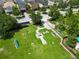 Aerial view of a well-maintained community dog park with agility equipment and lush green space, surrounded by residential homes at 1044 Oliveto Verdi Ct, Brandon, FL 33511