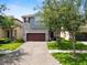 Charming two-story home featuring a paver driveway, manicured lawn, and mature trees at 1044 Oliveto Verdi Ct, Brandon, FL 33511