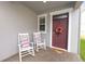 Charming front porch featuring rocking chairs and a decorative wreath on the front door at 1044 Oliveto Verdi Ct, Brandon, FL 33511