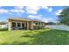 Lush backyard with a spacious lawn, covered patio, and a fenced perimeter for privacy at 11825 Frost Aster Dr, Riverview, FL 33579
