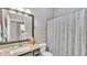 Neutral bathroom featuring granite counters, a large framed mirror and a shower with curtain at 11825 Frost Aster Dr, Riverview, FL 33579