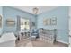 Serene blue Bedroom with crib, side chair, playful wall art, and soft natural light at 11825 Frost Aster Dr, Riverview, FL 33579