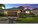 Charming single-story home with stone accents, a well-manicured lawn, and a brick paved driveway at 11825 Frost Aster Dr, Riverview, FL 33579