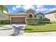 Charming single-story home with stone accents, lush landscaping, and a brick driveway at 11825 Frost Aster Dr, Riverview, FL 33579