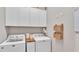 Well-organized laundry room features modern appliances, storage cabinets, and woven baskets at 11825 Frost Aster Dr, Riverview, FL 33579