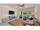 Spacious living room featuring tile floors, ceiling fan, and large windows overlooking the backyard at 11825 Frost Aster Dr, Riverview, FL 33579