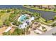 Aerial view of a resort-style pool and amenities with a lake backdrop and lush landscape at 11825 Frost Aster Dr, Riverview, FL 33579