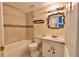 Bathroom features tile flooring, a shower-tub combo, a vanity, and a framed mirror at 12212 Hidden Brook Dr, Tampa, FL 33624