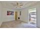 Bright bedroom featuring a ceiling fan, carpet, and a door to the exterior at 12212 Hidden Brook Dr, Tampa, FL 33624
