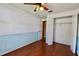 Bright bedroom with wood floors, blue and white accent walls, a fan, and closet at 12212 Hidden Brook Dr, Tampa, FL 33624