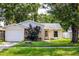 Charming single-story home with a well-maintained lawn and mature trees provides great curb appeal at 12212 Hidden Brook Dr, Tampa, FL 33624