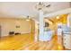Open-concept living room and kitchen with wood floors, updated lighting, and neutral color palette at 12212 Hidden Brook Dr, Tampa, FL 33624