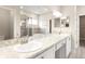Bright bathroom featuring double sinks with a granite countertop, a glass-enclosed shower, and a separate tub at 2422 White Ladyfish Rd, Wimauma, FL 33598